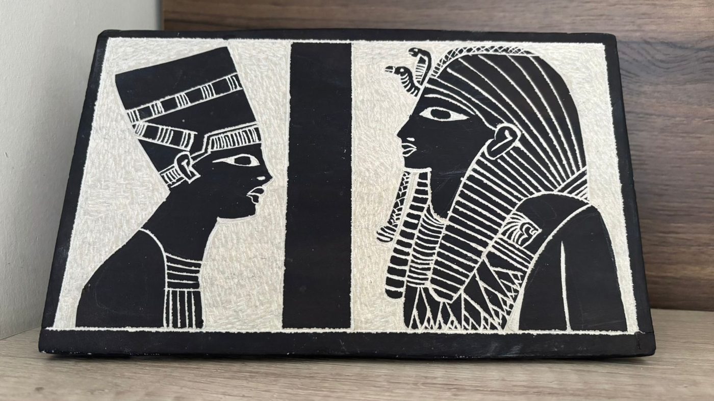 Relief carving of an Egyptian pharaoh and queen, on stone, likely basalt, Luxor, Egypt