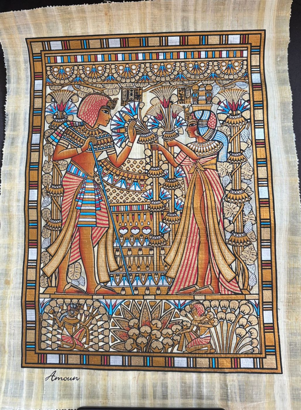 Papyrus painting of a pharaoh and queen exchanging lotus flowers, with hieroglyphic borders, Luxor, Egypt