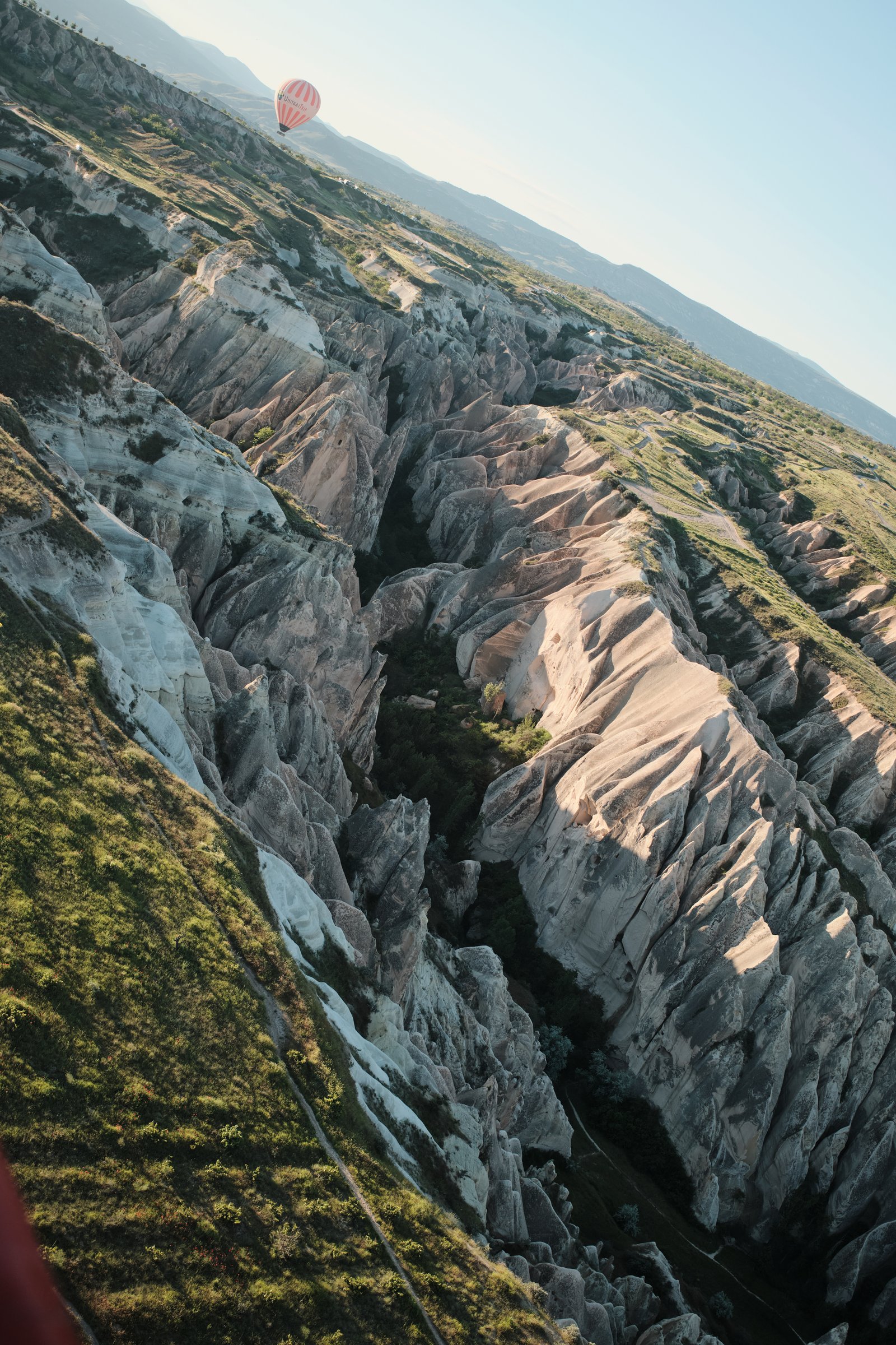 A single balloon over the deep, jagged valleys carved into Cappadocia's rock.