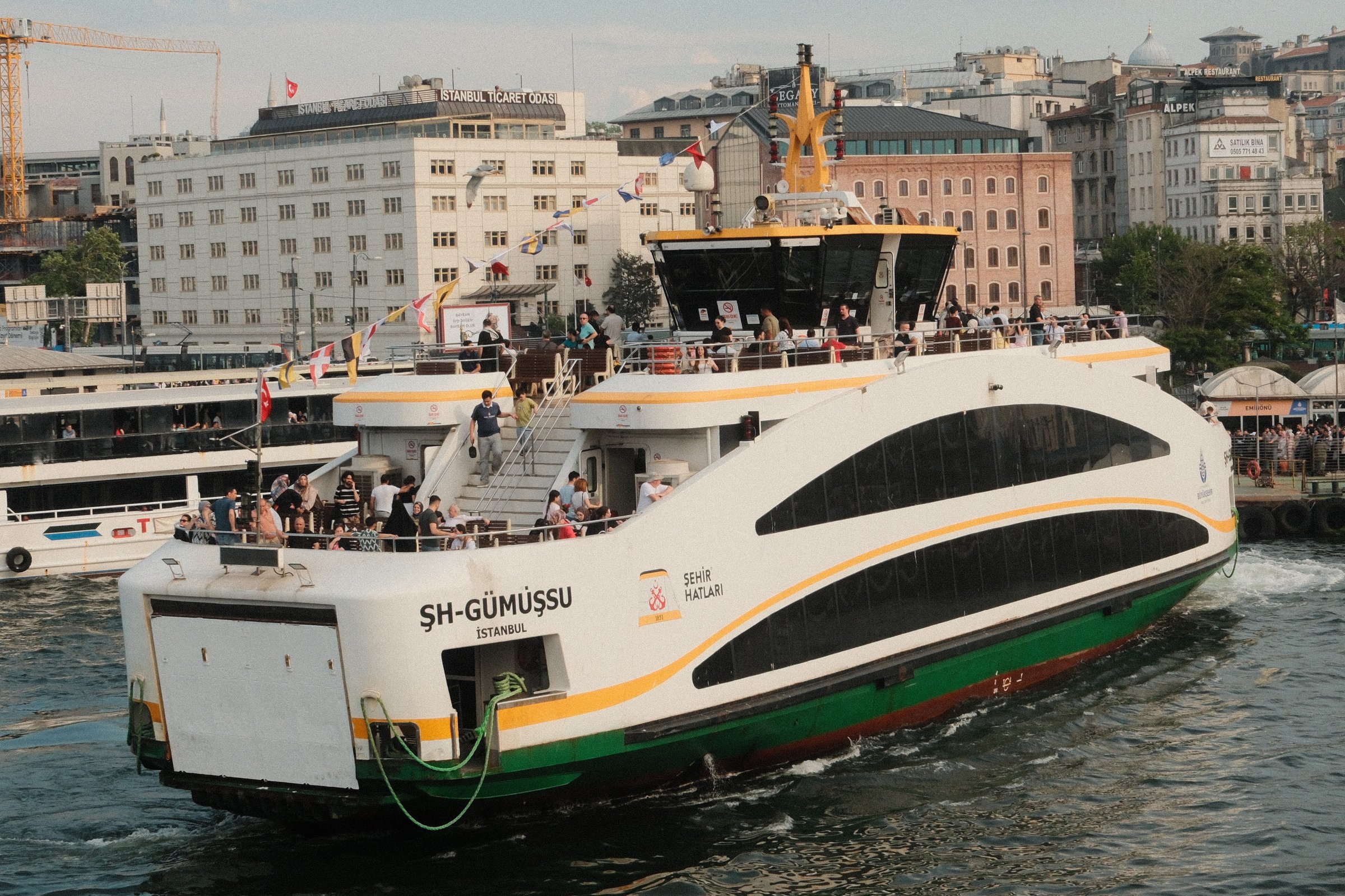 A ferry crossing the Bosphorus, another boat trailing behind it in the wake.