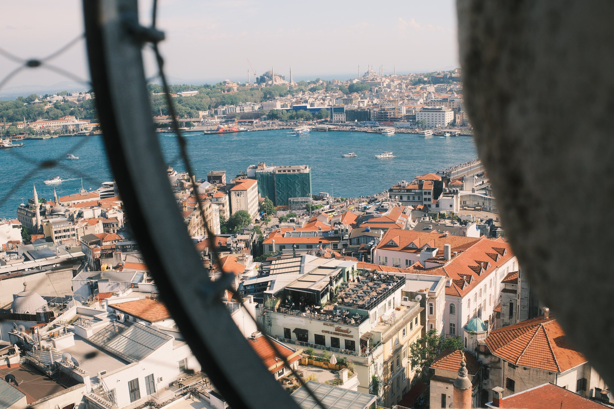 The same view over the city, framed through Galata Tower's window railing.